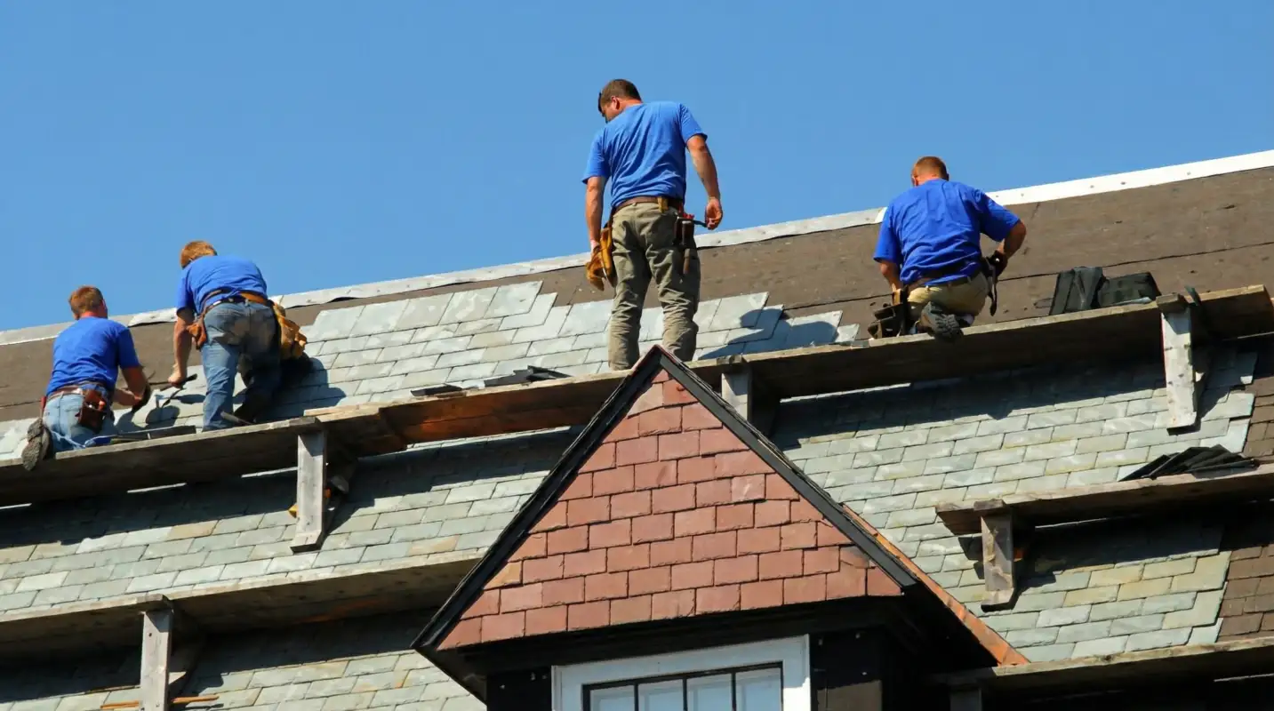 Roof replacement in progress with a team of professional contractors installing new shingles on a residential home in Cedar Rapids, IA
